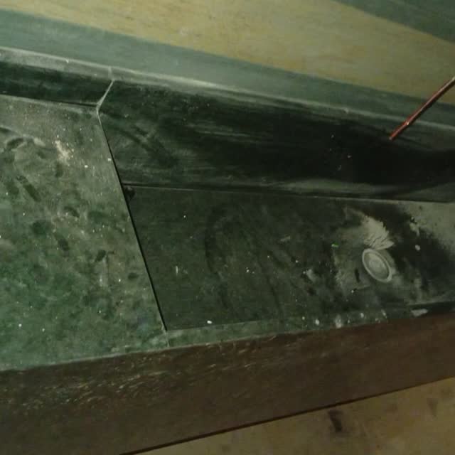 Bancada em granito verde: Bancada em granito verde escuro com cuba esculpida e rebaixo para escorredor, durante a instalação.