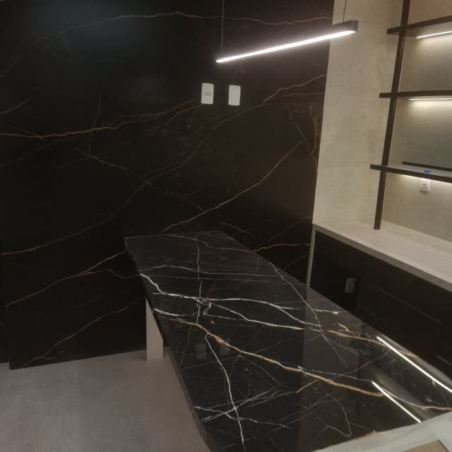 Painel e bancada em mármore preto: Parede e bancada em mármore preto com veios dourados, integradas ao nicho iluminado e à marcenaria escura.