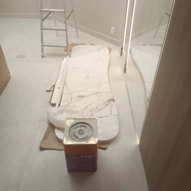 Chapa preparada na obra: Chapa de mármore claro sendo conferida e ajustada no local, antes do assentamento.