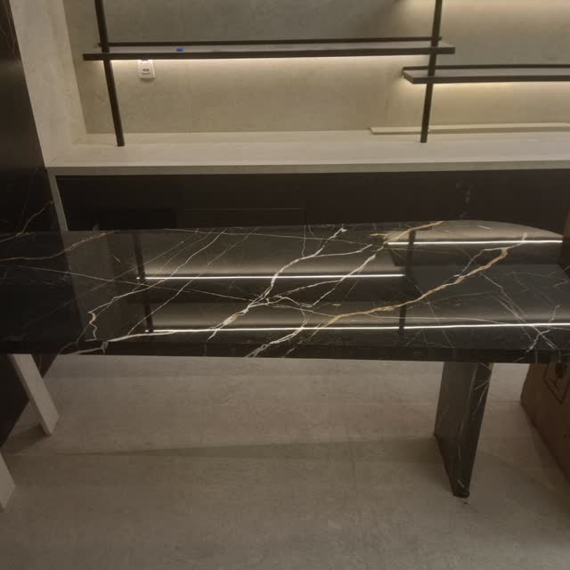 Bancada e mesa em mármore preto: Conjunto de bancada e mesa em mármore preto com veios brancos, em fase de montagem.