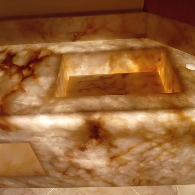 Bancada de ônix, detalhe: Detalhe da bancada de ônix retroiluminada — o veio da pedra acende de dentro para fora.