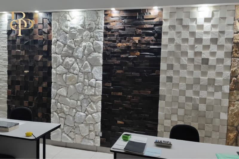 Painéis de mostruário no showroom da Brilho das Pedras, com mosaicos e revestimentos em pedra natural expostos lado a lado.